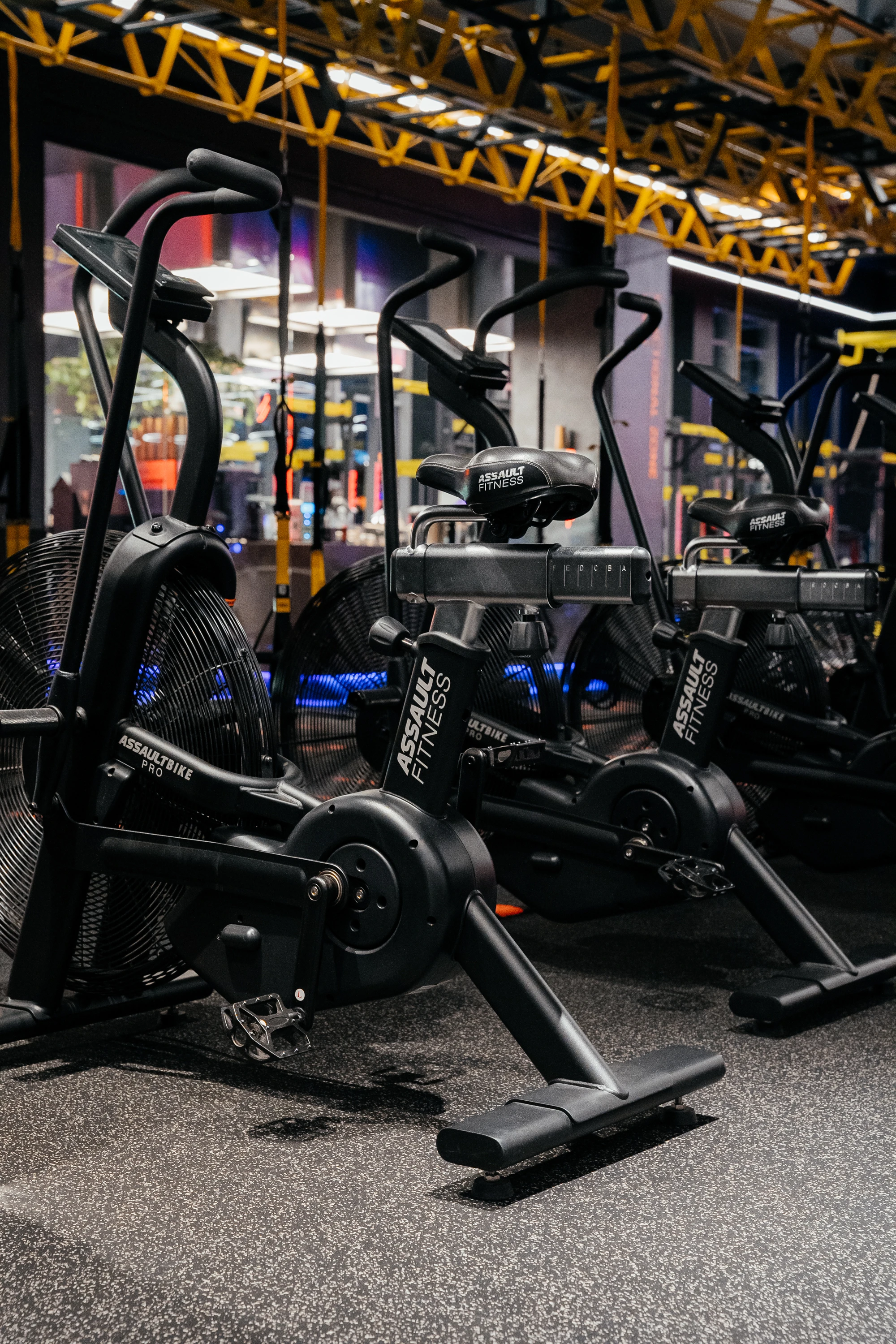 Просторий зал з біговими доріжками та іншими видами бігових тренажерів з неоновим освітленням